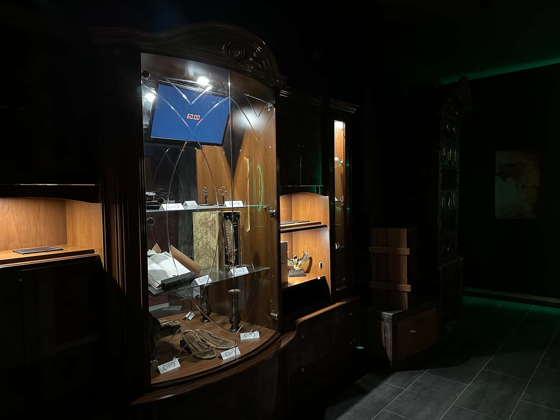 Beleuchtete Glasvitrine mit Ausstellungsstücken im Escape Room Artefakt in Rosenheim