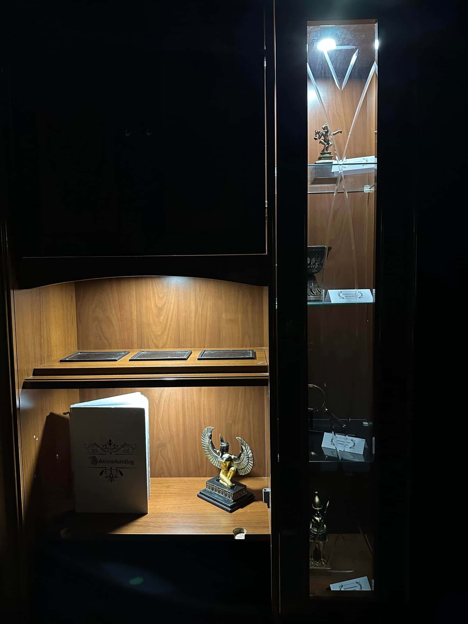 Beleuchtetes Vitrinenfach mit geflügelter Figur im Escape Room Artefakt in Rosenheim