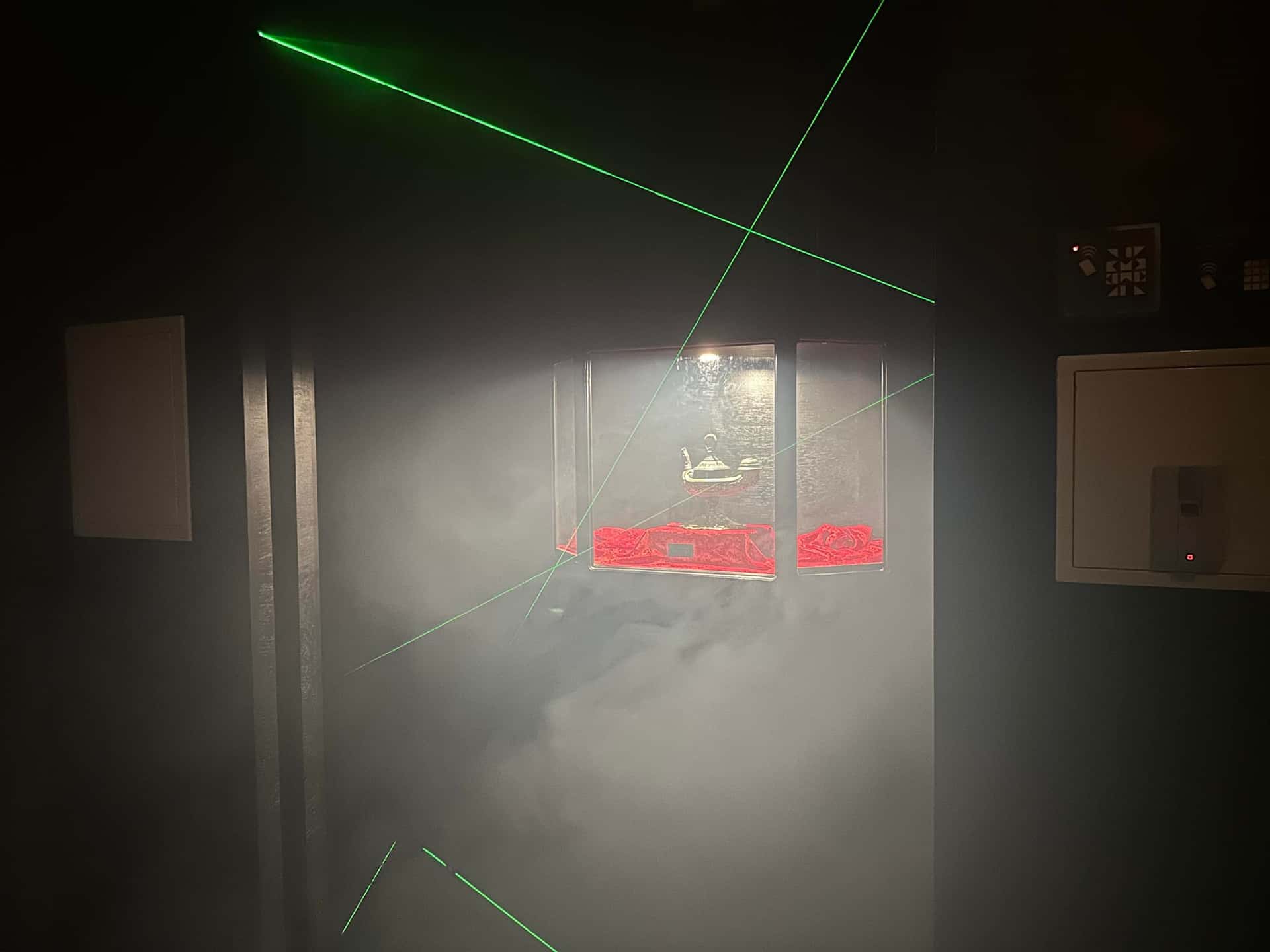 Grüne Laserstrahlen im Nebel vor der Vitrine mit der Wunderlampe im Escape Room Artefakt in Rosenheim