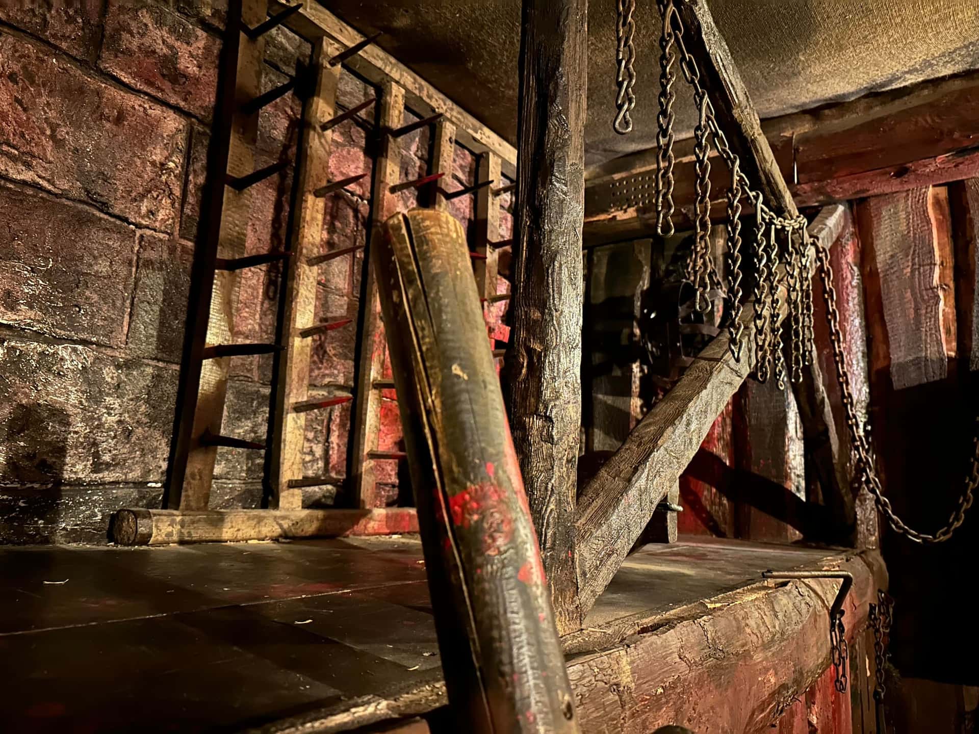 Folterkeller mit Ketten, Holzleiter und Steinwänden im Escape Room Der Henker in Rosenheim