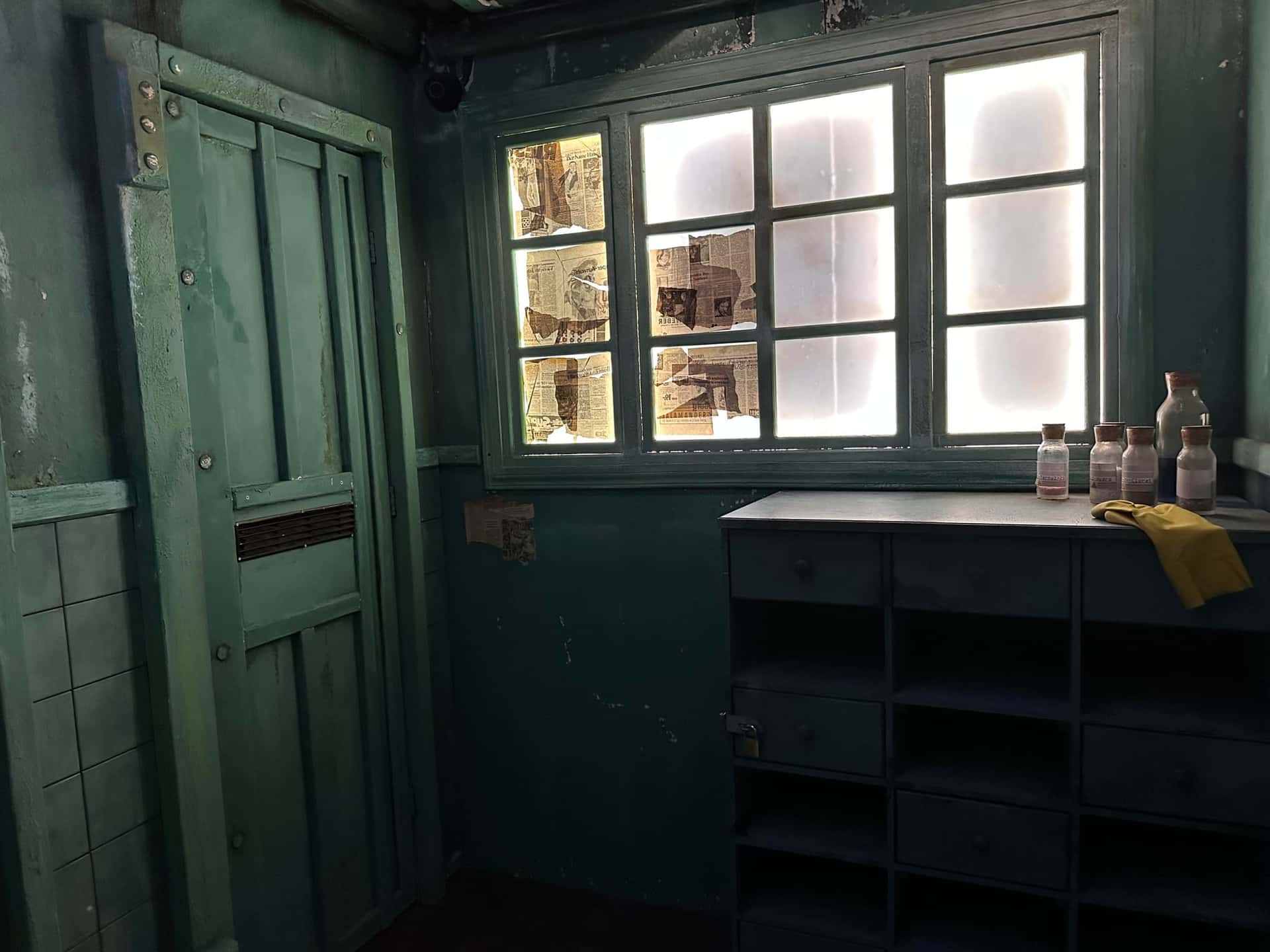 Klinikraum mit beleuchtetem Fenster voller Notizen und Medikamentenschrank im Escape Room Madhouse (Infection) in Rosenheim