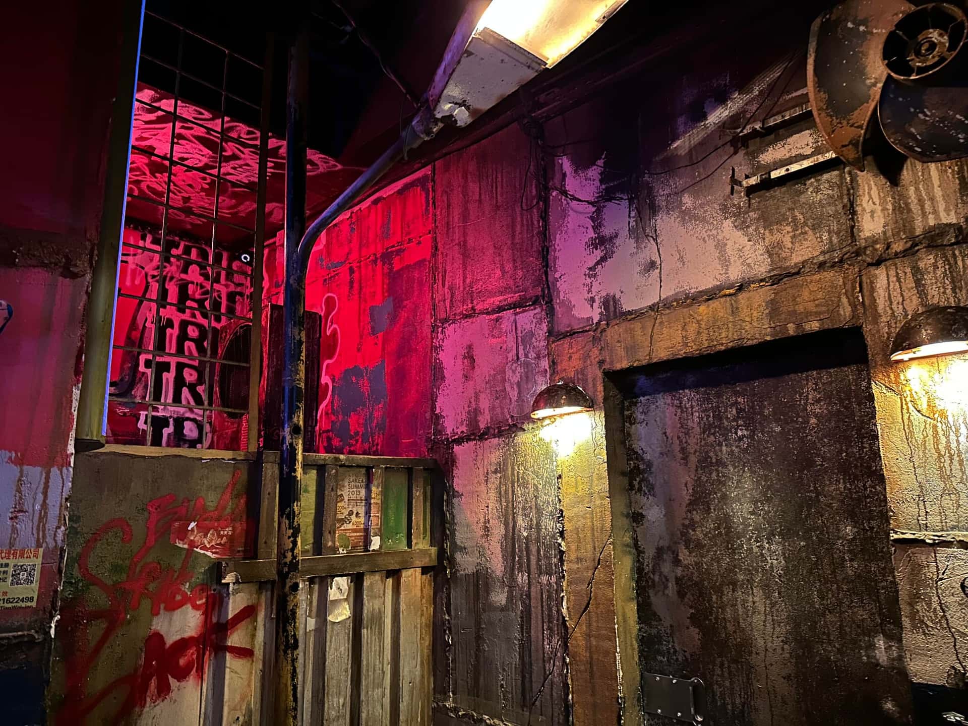 Graffiti-Wände in rotem und violettem Licht im Escape Room Robot Paranoia in Rosenheim
