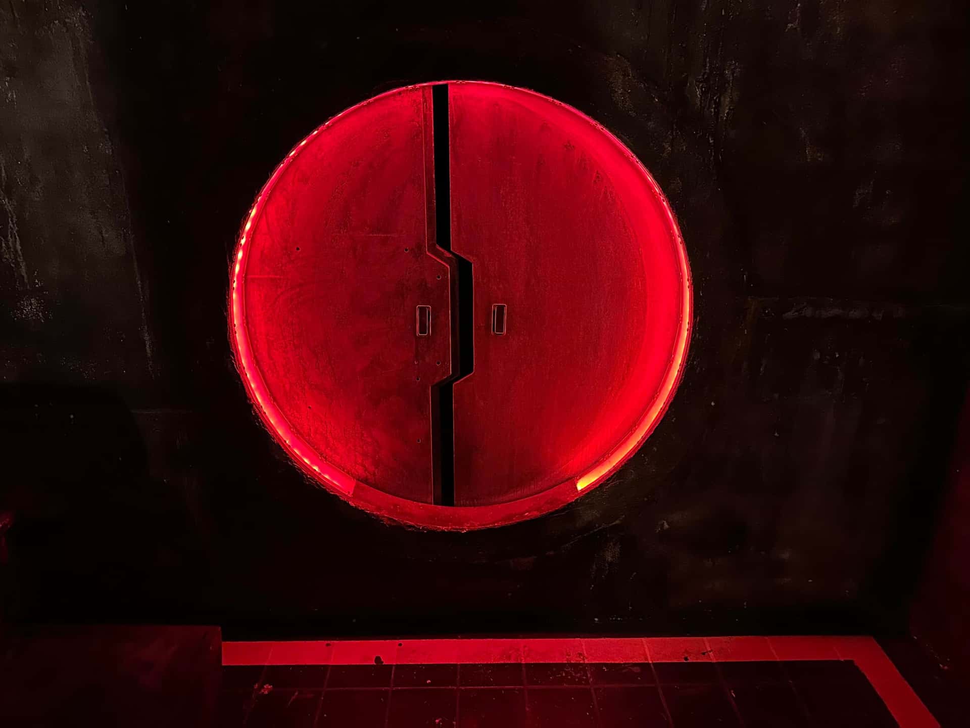 Rot leuchtende runde Tür im Escape Room Robot Paranoia in Rosenheim