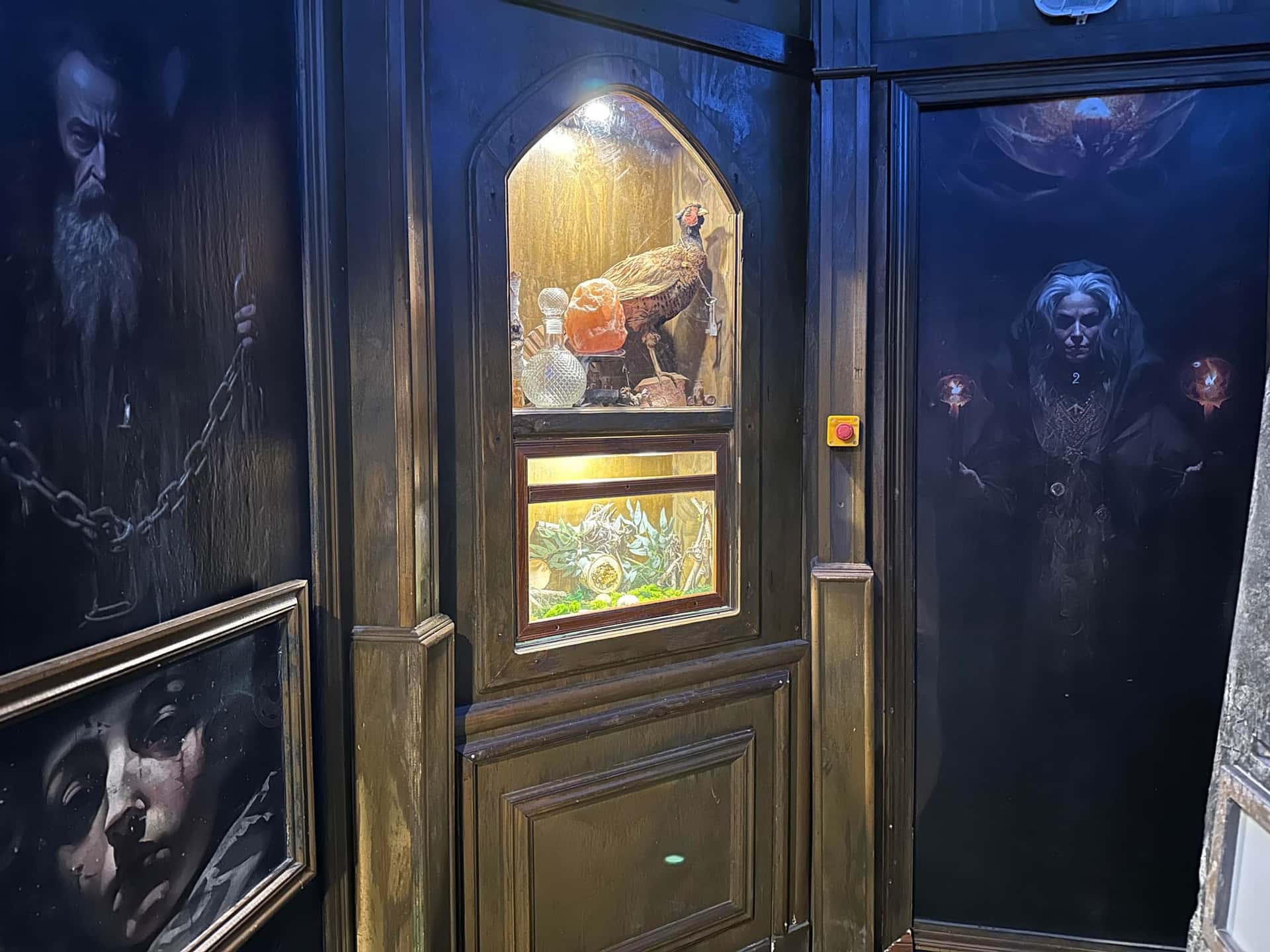 Gemälde von Hexe und Zauberer neben beleuchteter Nische im Escape Room Die Zauberschule in Rosenheim