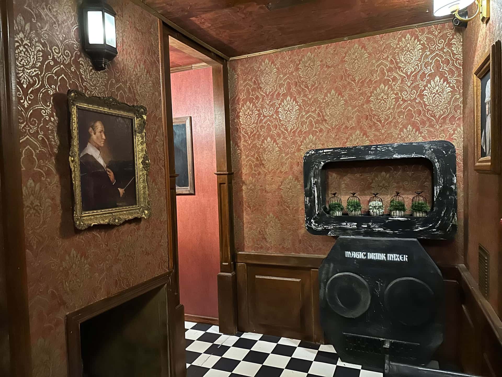 Zaubertrank-Apparatur und Porträt an der Damasttapete im Escape Room Die Zauberschule in Rosenheim