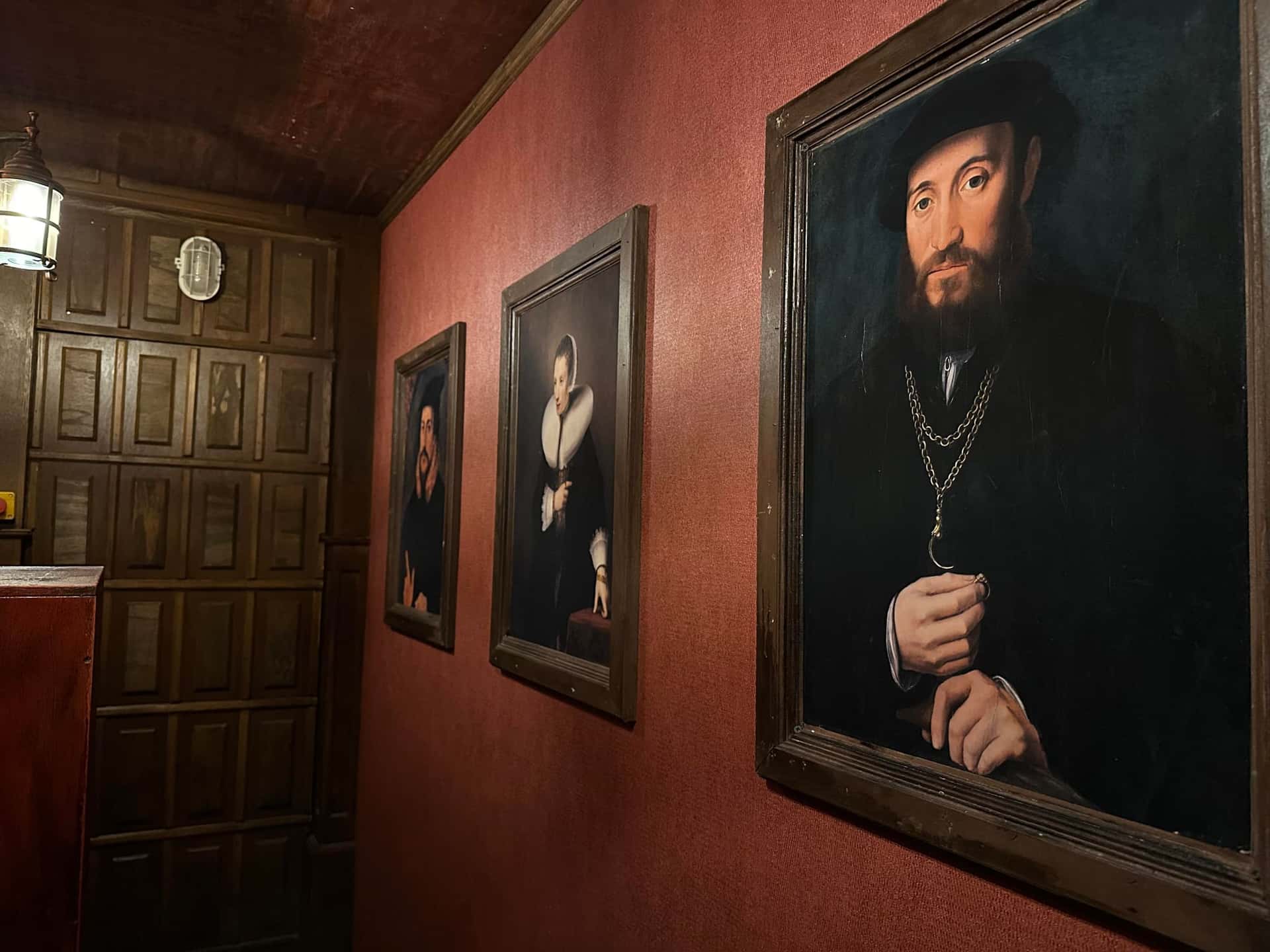 Flur mit großen historischen Porträtgemälden im Escape Room Die Zauberschule in Rosenheim