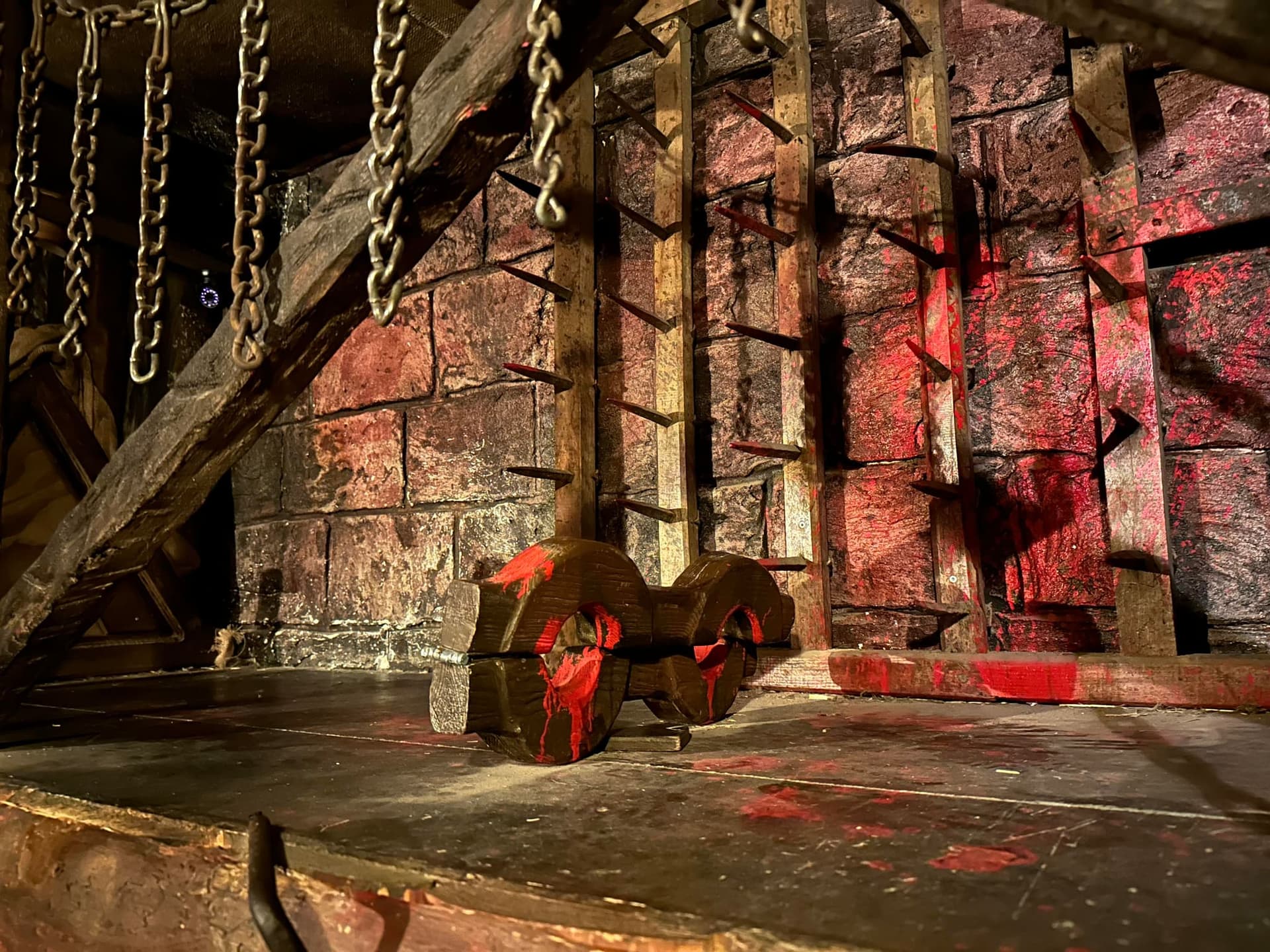 Pranger mit Ketten im rot beleuchteten Folterkeller im Escape Room Der Henker in Rosenheim